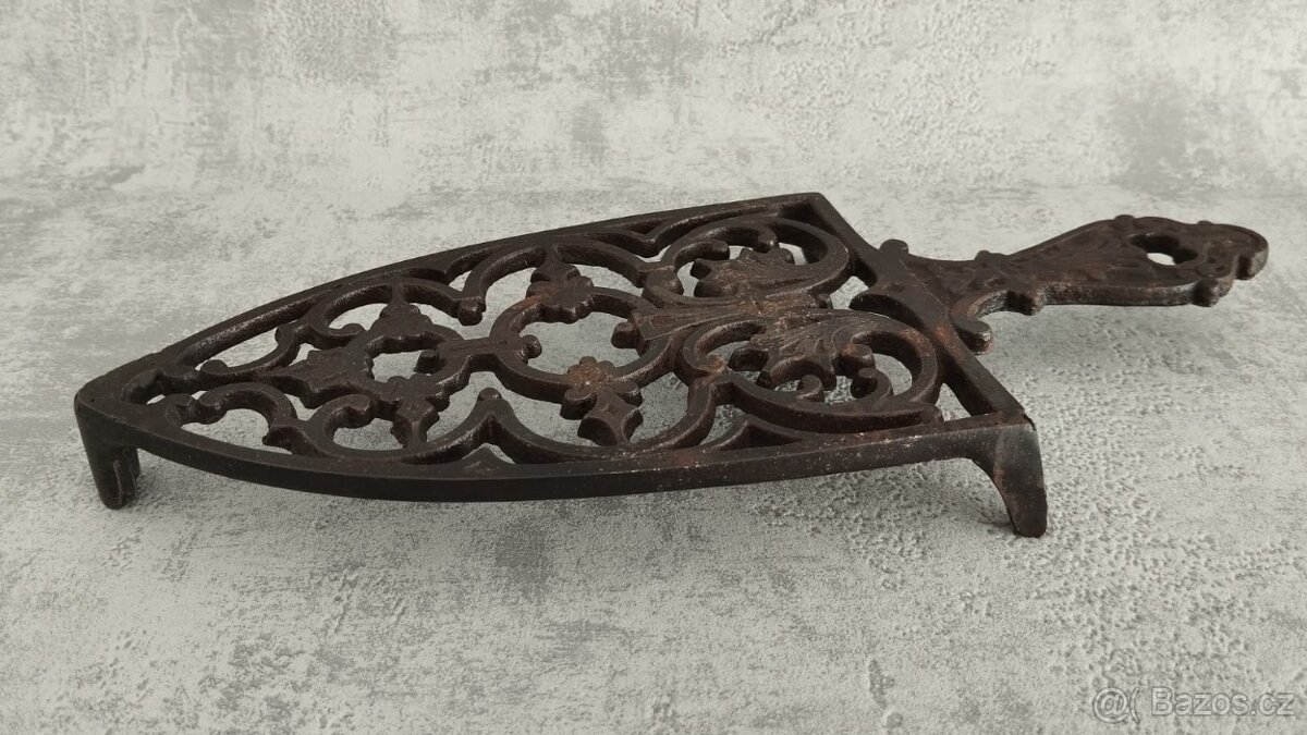 Krásná stará zdobená podložka pod starou žehličku.