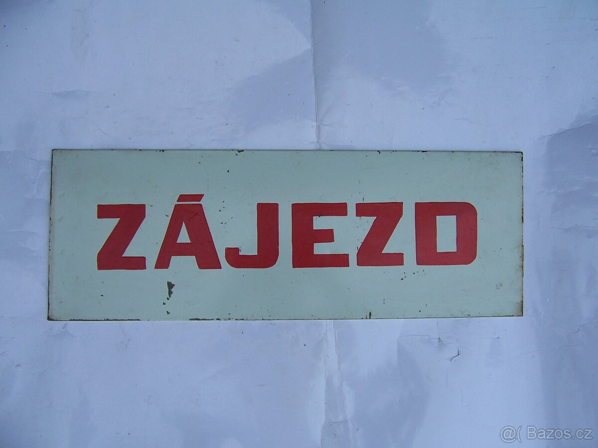 plechová cedule s červeným nápisem Zájezd