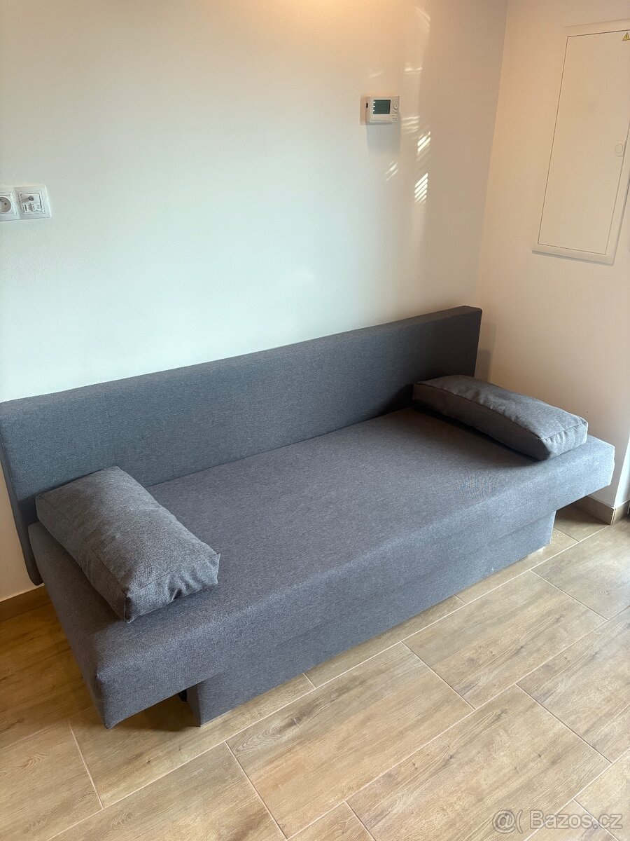 Šedý rozkládací gauč