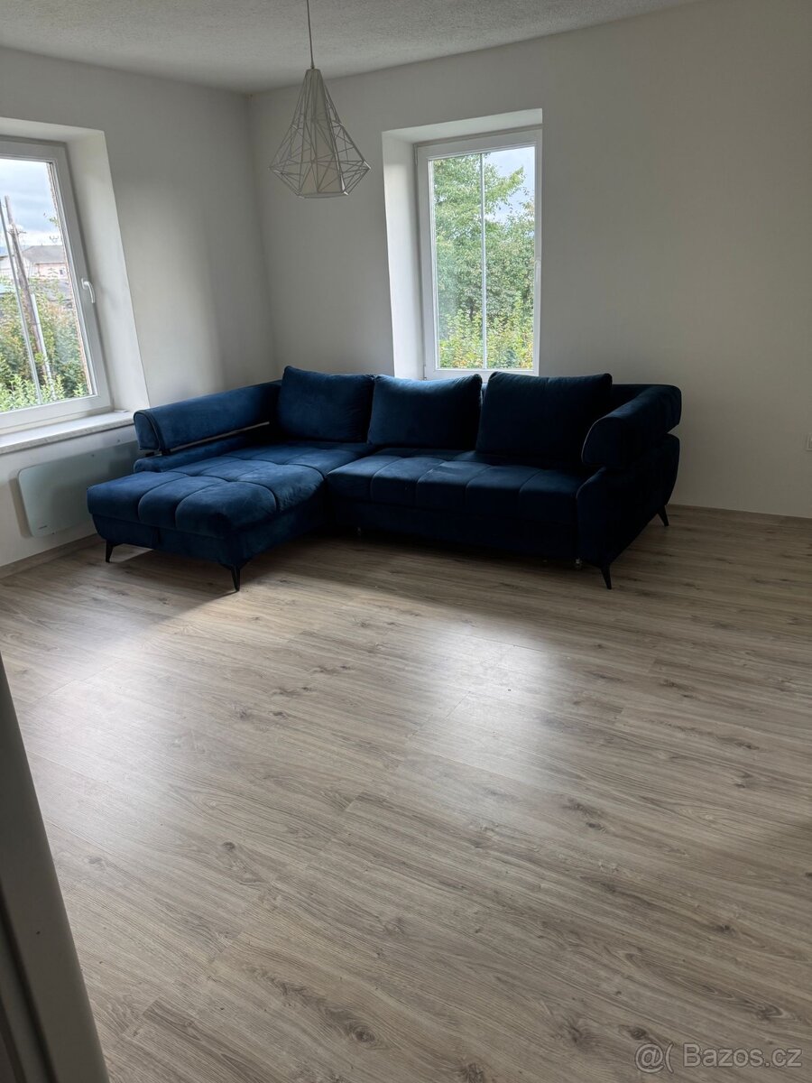 Modrý rozkládací gauč s úložným prostorem