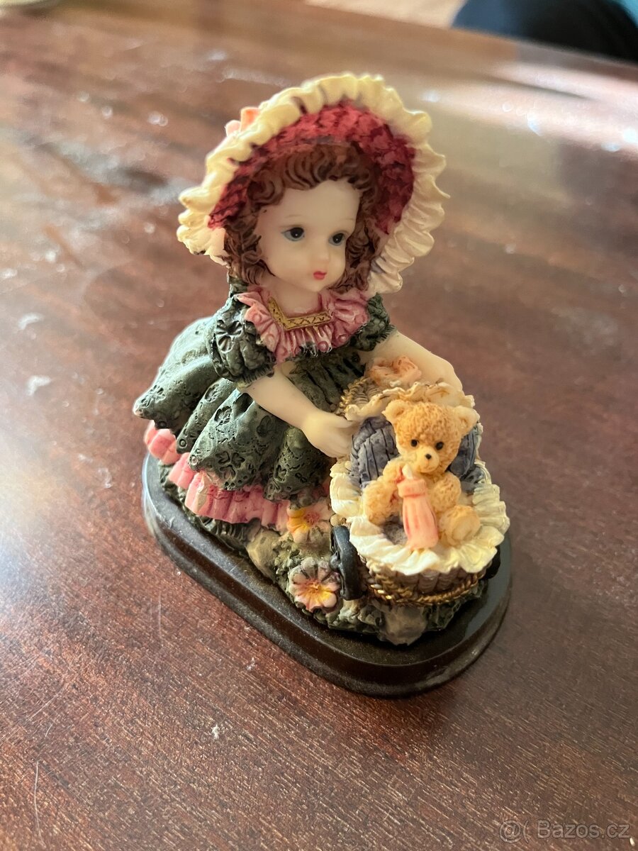 soška panenky s medvídkem