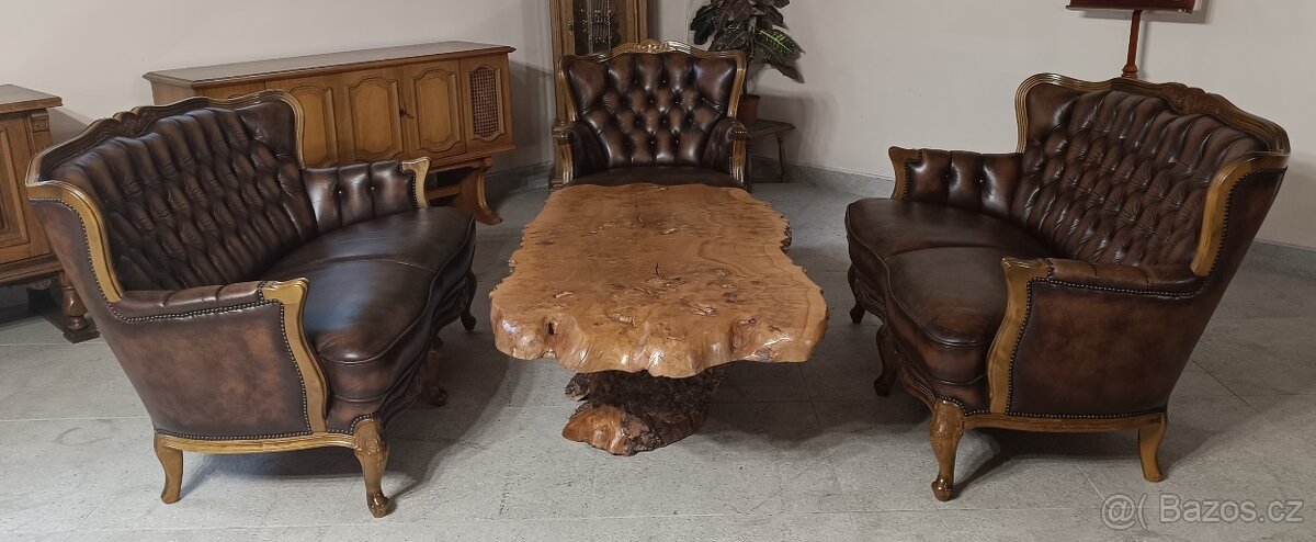 Luxus, kožená Chesterfield sedací souprava a stůl.