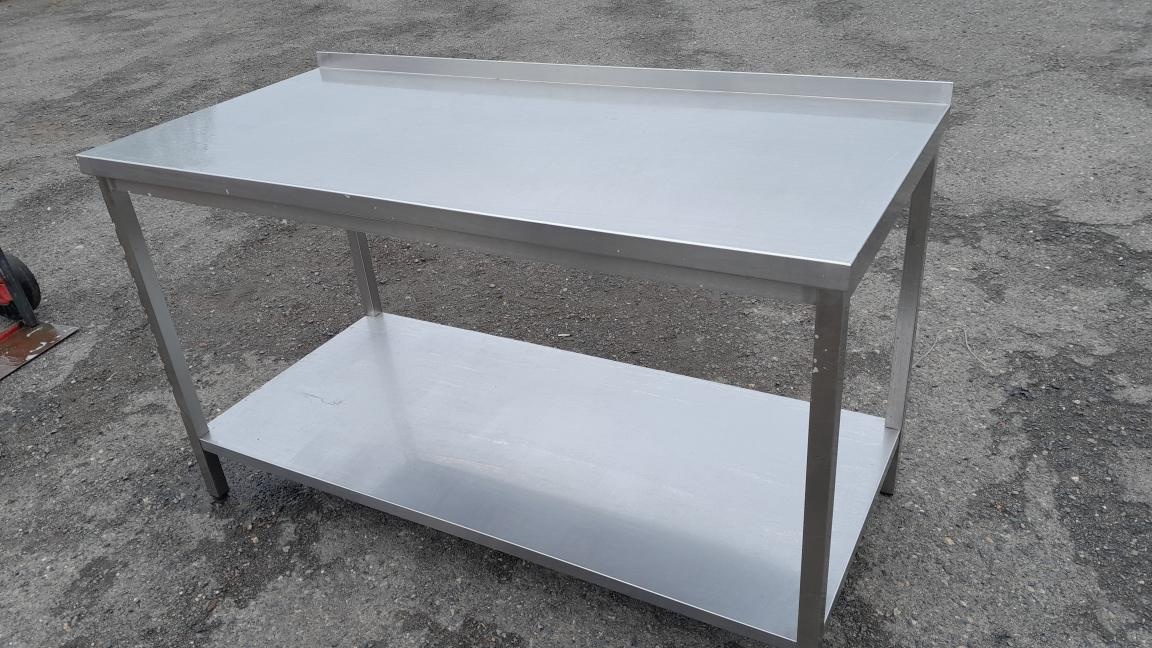 Nerez stůl 150x70x85-90 cm se spodní polici a lemem.