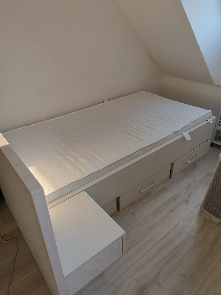 Postel i s matrací a nočním stolkem