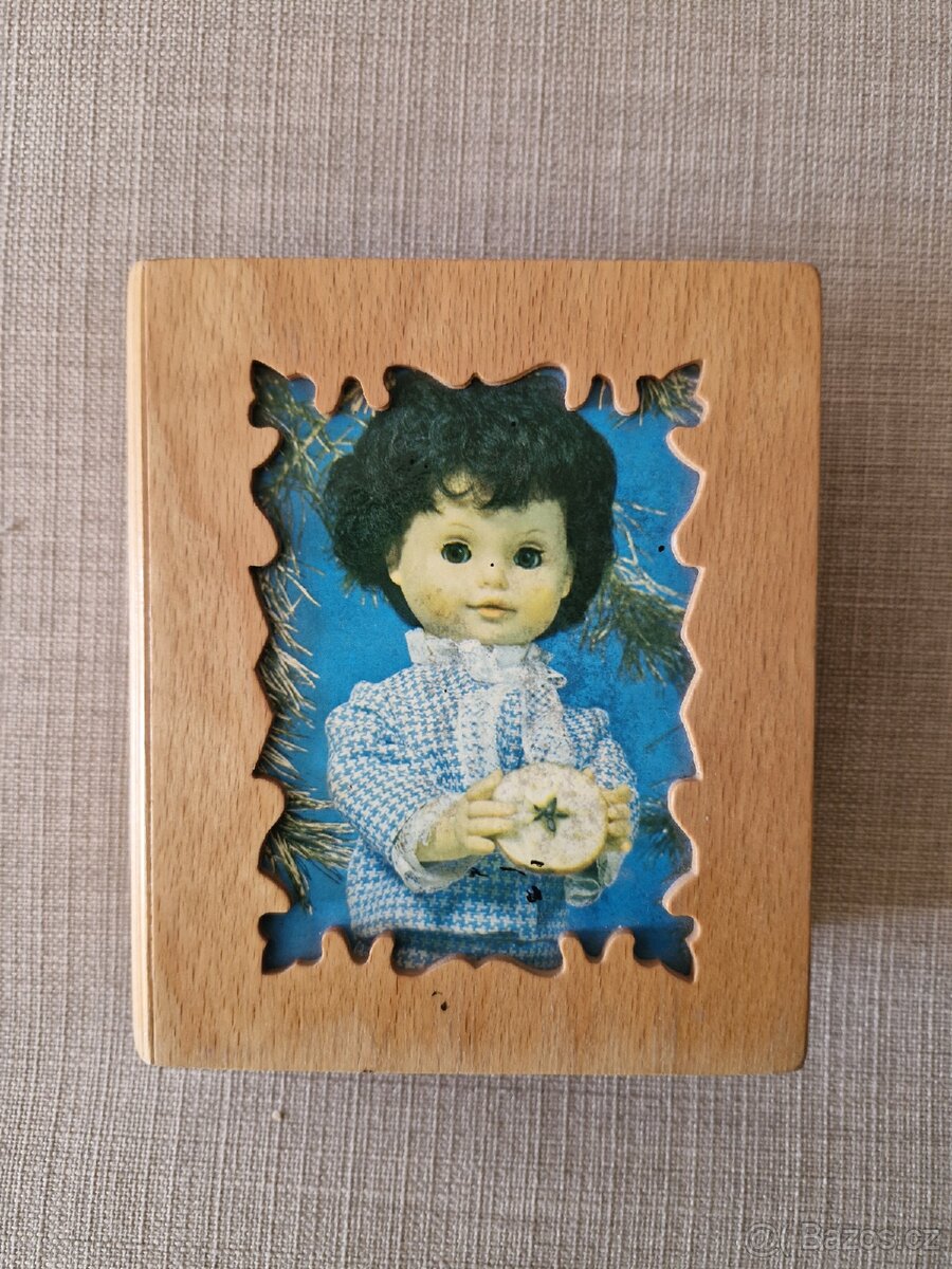 Dřevěná pokladnička ve tvaru knížky.