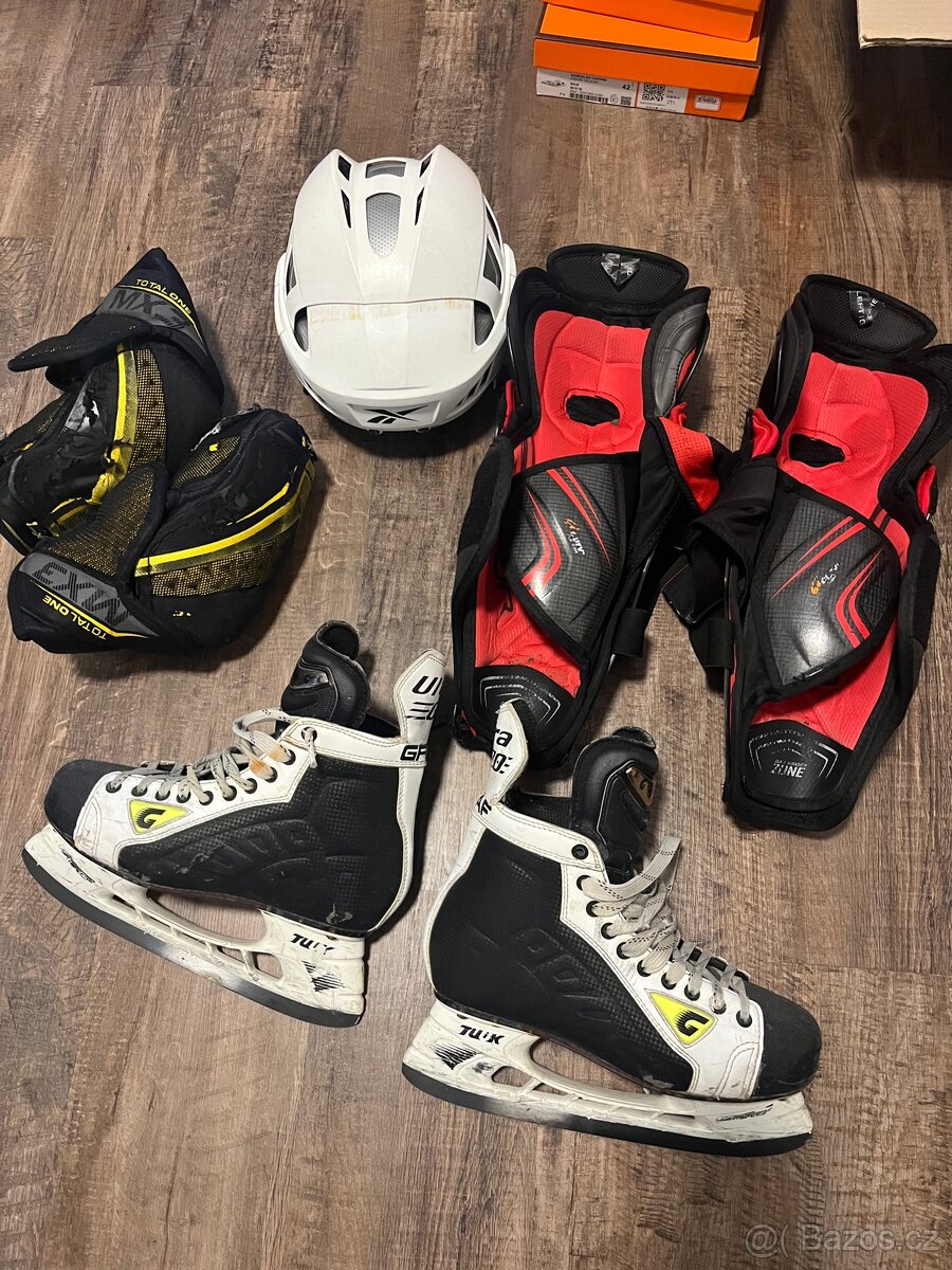 Lokty holeně Bauer, helma Reebok, brusle Graf