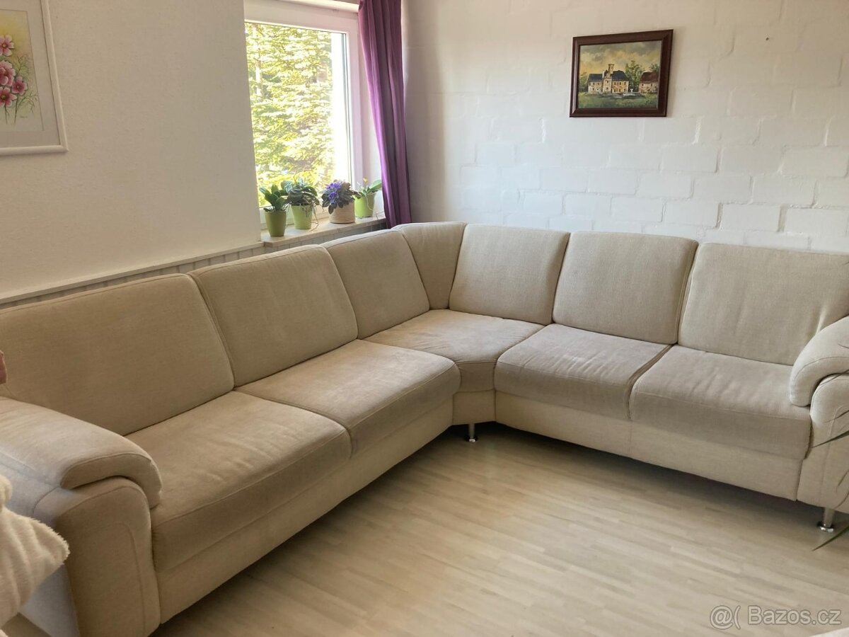 Velký rohový béžový gauč.
