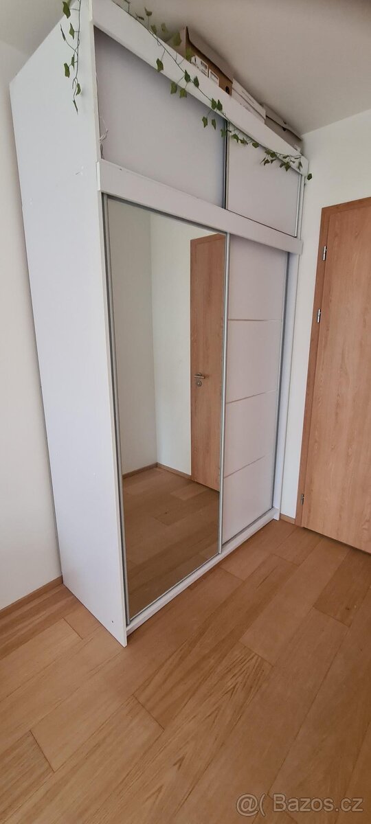Bílá šatní skříň s posuvnými dveřmi, zrcadlem a nástavcem