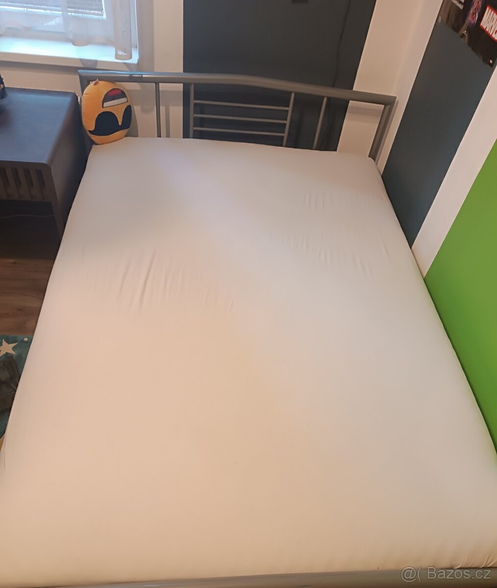 Postel s kovovým rámem a matrací ze spánkového studia