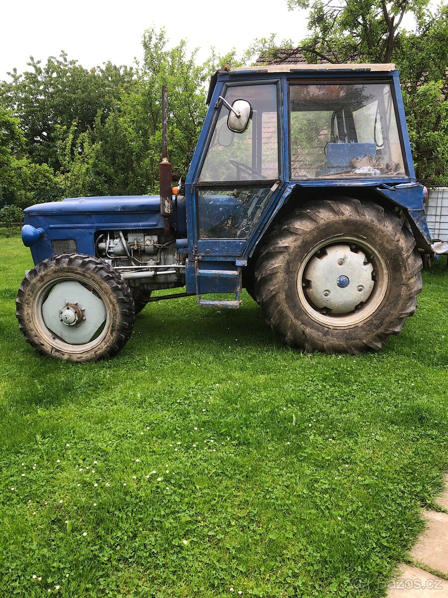 Traktor 6745 s dvoukolovou vlečkou a pluhem