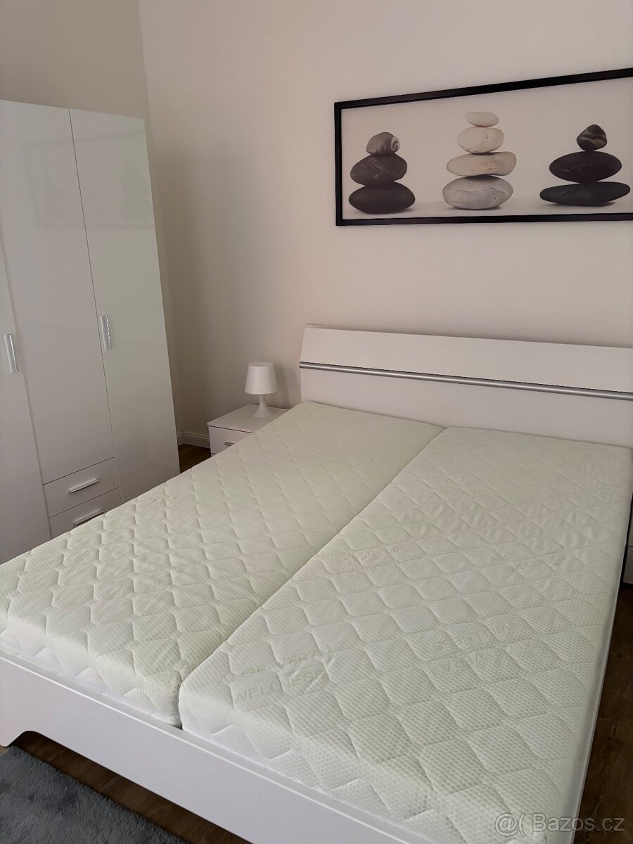 Krásná bílá postel s nočními stolky