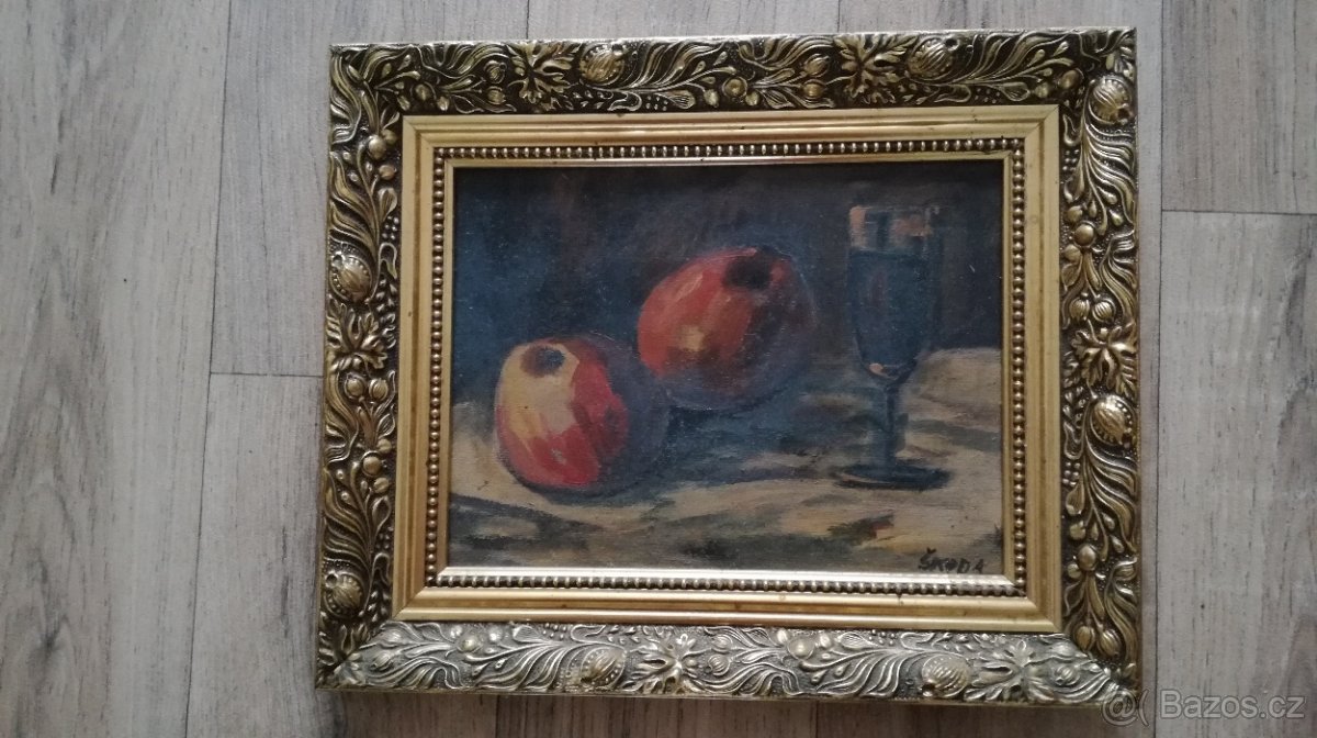 Obraz jablka a pohár ve zlatém rámu.