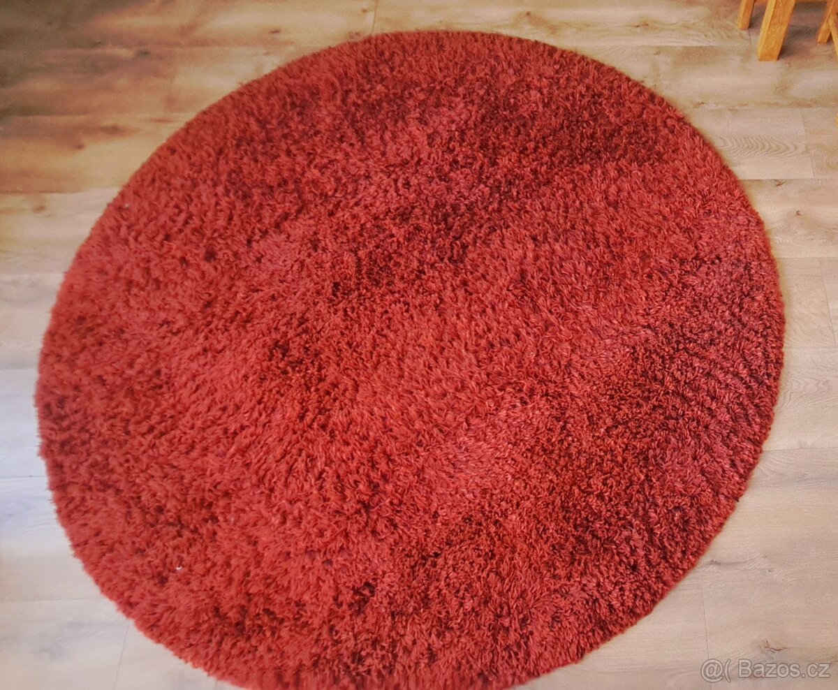 Velký krásný červený kulatý koberec