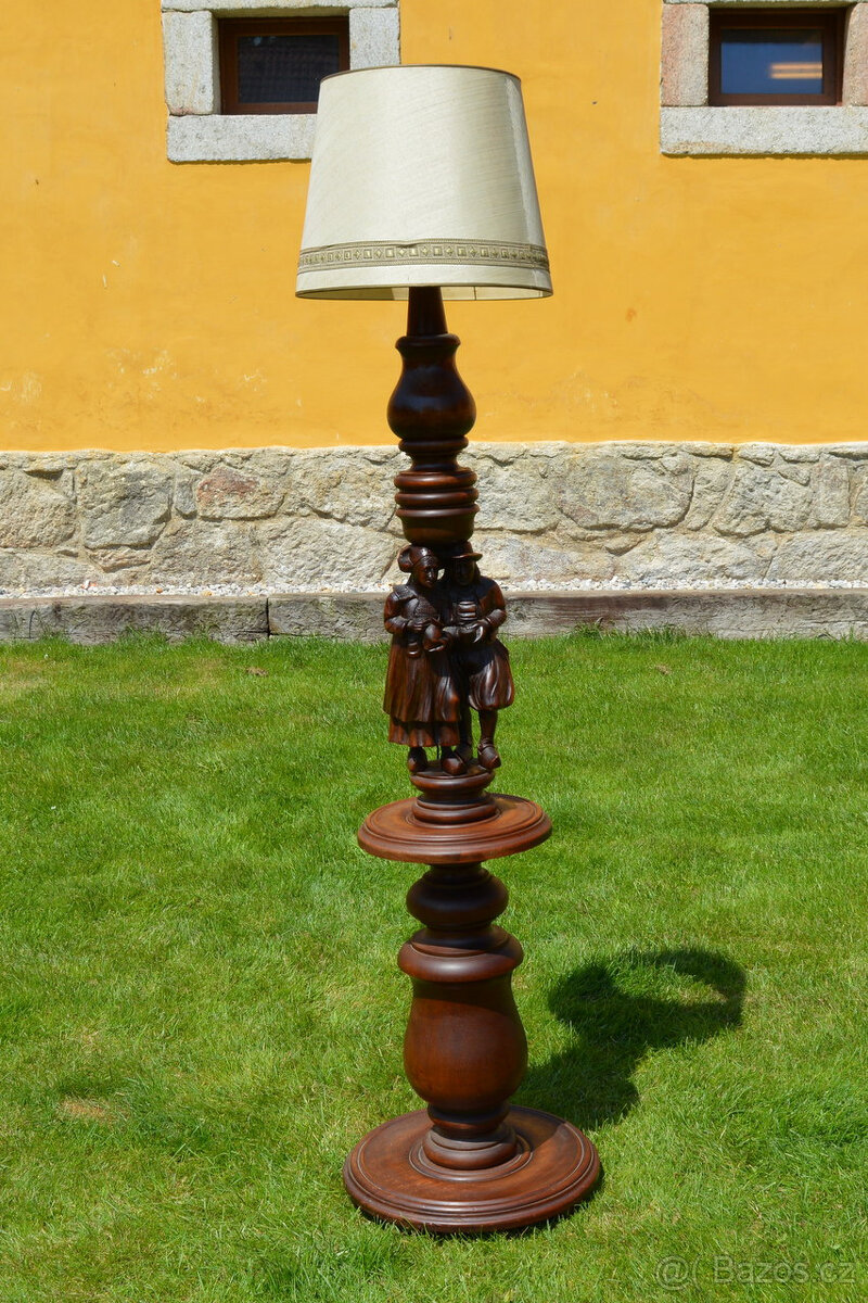 Podlahová stojací lampa s vyřezávanými figurkami