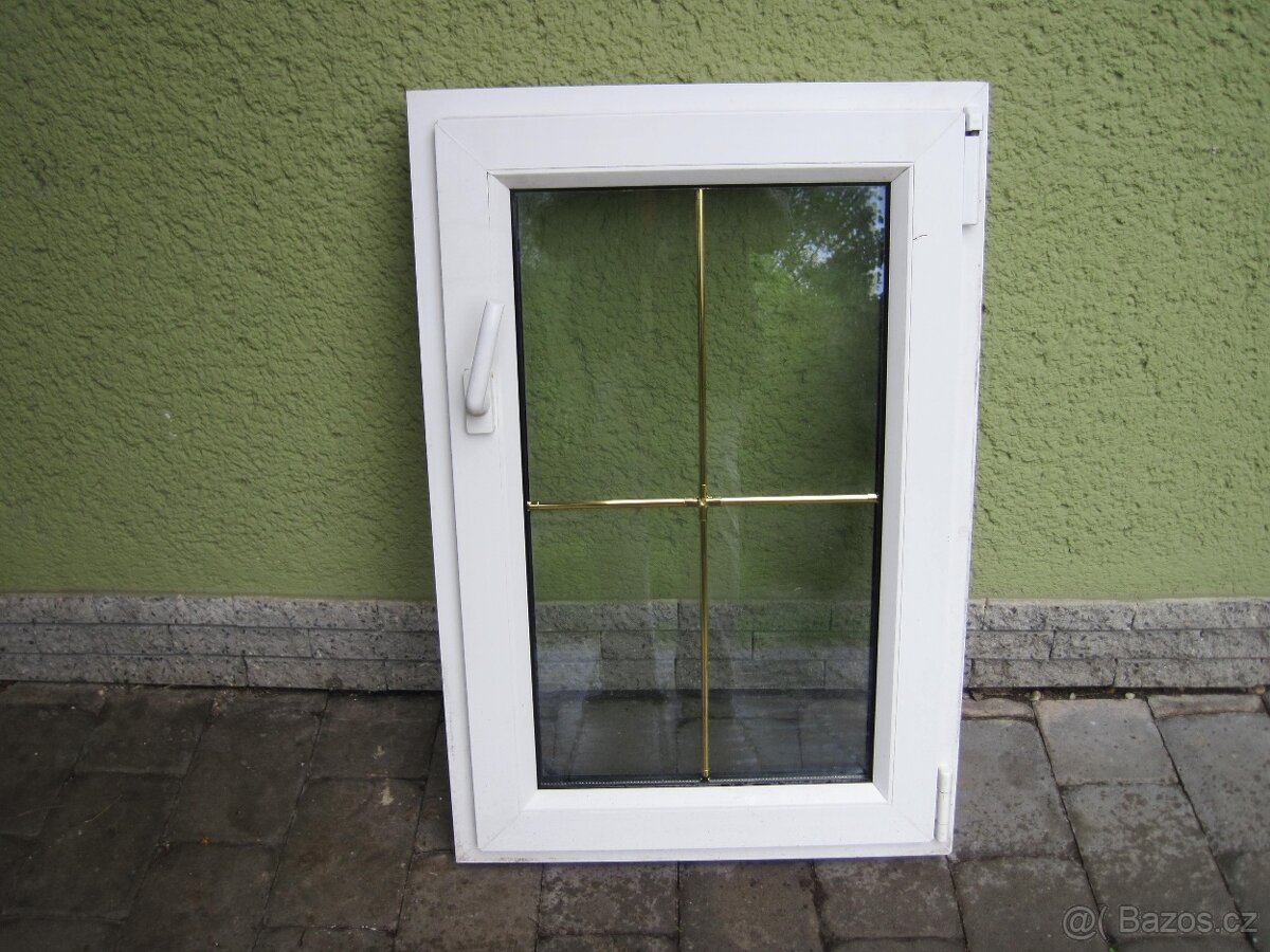 bílé plastové okno se zlatou mřížkou uvnitř