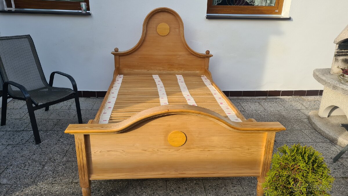 Masivní dřevěná postel s roštem.