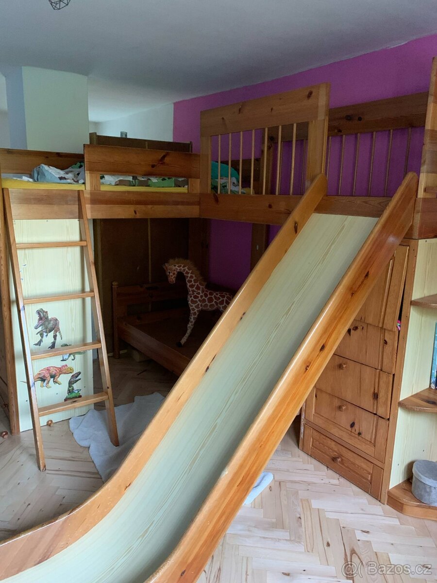 Dětská dvoupatrová postel s úložnými prostory a skluzavkou.