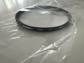 Krytka objektivu, popruh, clona, difuzer, očnice.. - 12