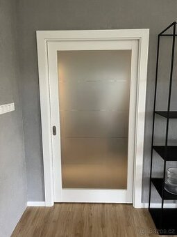 Posuvné bílé interierové dveře se sklem, 100cm