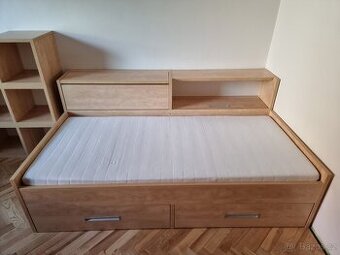 Sestava postel, skříňka a poličky.