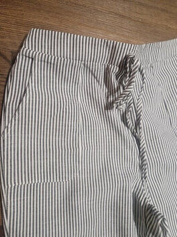 Kalhoty bílé široké s jemným šedým proužkem bavlněné.