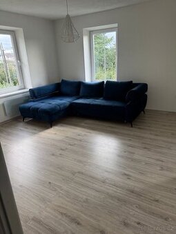 Modrý rozkládací gauč s úložným prostorem