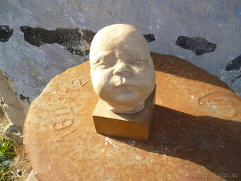 socha hlavy dítěte z ateliéru po sochaři