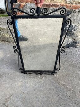 Staré zrcadlo v kovaném rámu.