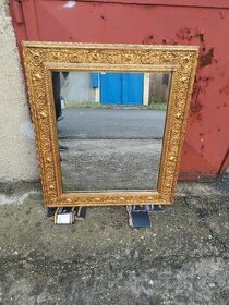 Staré zrcadlo ve zlatem rámu.