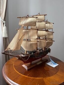 Model dřevěné loďe s plachtami na podstavci