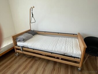 Polohovací elektrická postel s hrazdou