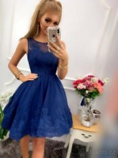 Nádherné tmavě modré šaty zdobené krajkou.