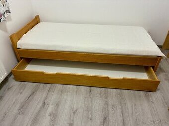 Jednolůžková postel dubu s výsuvným úložným prostorem.