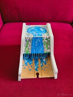 dřevěný tunel s vodopádem k vláčkodráze