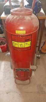 Starý práškový hasící přístroj s kolečky a nápravou