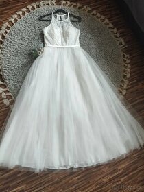 Bílé, romantické svatební šaty s bohatou týlovou sukní.