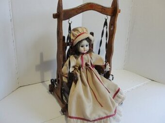 Stará, porcelánová panenka na houpačce