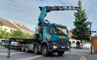 Řidič/ka vozidla s hydraulickou rukou.