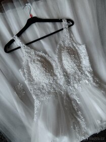 Nádherné svatební šaty zdobené krajkou.