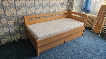 P: Masivní dřevěná postel s úložným prostorem