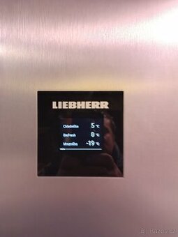 Stříbrná kombinovaná lednice Liebherr.