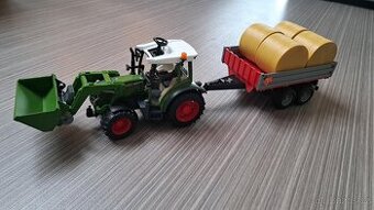 Traktor Bruder s čelním nakladačem a přepravníkem na balíky
