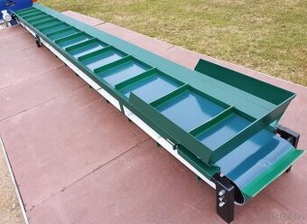 Dlouhý pásový dopravník s hradítky