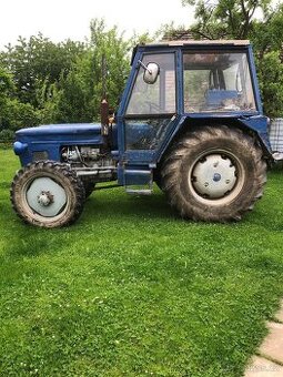 Traktor 6745 s dvoukolovou vlečkou a pluhem