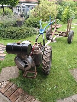 Malotraktor s vlekem na dřevo.