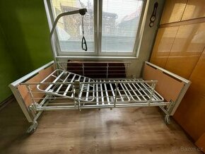 Elektrická polohovací postel Invacare s hrazdou