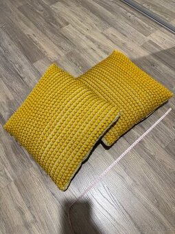 Tyto pletené žluté polštáře mají texturovaný,