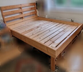 Masivní vysoká rustikální dřevěná manželská postel.