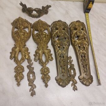 Staré mosazné ozdoby na skříň.