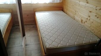 Dřevěná postel včetně matrace a roštu.